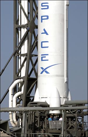 SpaceX's Falcon 9 rocket, shown on the launch complex at Cape Canaveral Air Force Station in Florida, is the first to fly into a new frontier for business. The company's cargo-carrying Dragon space capsule is set to arrive early today near the International Space Station for tests.