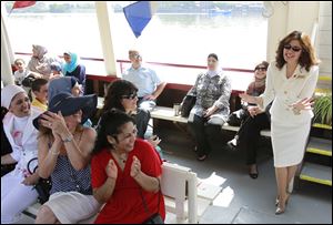 Najwa Badawi, standing, gets a round of applause from her students as they set out aboard the Sandpiper. Wednesday's excursion included foods of many cultures as well as line dancing plus Arabic music and all-American tunes including 'Yankee Doodle Dandy' and 'Hail to the Chief.'