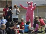  Principal Jack Renz dons a pig costume then kisses a pig,
in front of his students at East Broadway Elementary, who exceeded by more than 10,000 pages the reading goal he had set for them. Lester Marks of Monroe, who owns Ned the pig, held him for the kiss Friday.