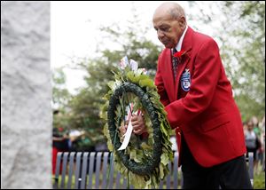 Ret. Col. Harold Brown of the Tuskegee Airmen places a wreath near the memorial at Waite High School.