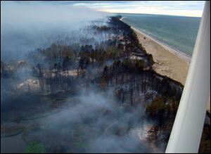 Officials warned of tough conditions and welcomed help from water-dumping aircraft from the Michigan National Guard to stop wildfire that has torched woodlands in Luce County, Michigan.