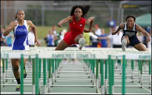 Brianna Scott Glover of Rogers, center, wins the 100 hurdles over Anthony Wayne’s Aisha Potts-Tyre, left, and Melody Farris of Lorain.