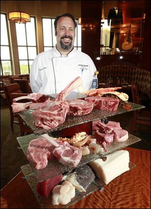 Brian Hein, executive chef at Hollywood Casino Toledo, with some of the cuts of meat and seafood featured at the Final Cut Steak and Seafood restaurant in the casino.