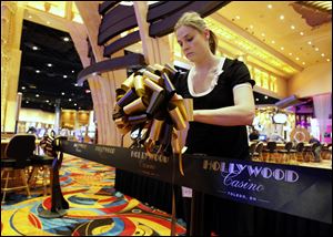 Brianna Chipps of Toledo puts up the ribbon to be cut at Hollywood Casino Toledo's  grand opening ceremony.