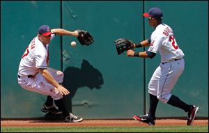 Cleveland Indians left fielder Shelley Duncan, left, and center fielder Michael Brantley try to corral an RBI double off the left center wall by Kansas City Royals' Alex Gordon in the fourth inning.
