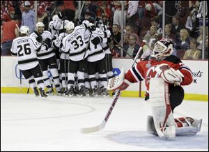 New Jersey Devils' goalie Martin Brodeur gets up from the ice after as the Los Angeles Kings celebrate their winning goal during the overtime period of Game 1.