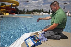 Mike Butcher, an inspector with the Toledo-Lucas County Health Department, checks the water quality at the Rolf Park Pool in Maumee, which opens for the season at noon Saturday.