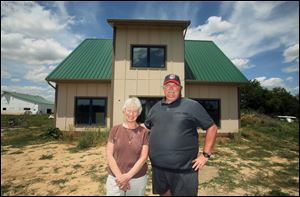 Sister Jane Frances Omlor and Mike Conner, director of the Sisters of St. Francis of Tiffin’s Earth Literacy Center, pose in front of the eco-friendly, energy-efficient straw-bale house.