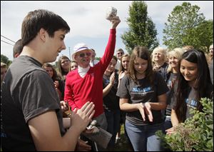 National Junior Honor Society officers at Bedford Junior High including Patrick Dillon, Allison Grim, and Abby Coulter, from left, applaud Monday as Wayne Thompson holds up the sawed-off end of a time capsule.
