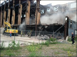 Debris at the Acme Power Plant in East Toledo was ignited today be workers dismantling the structure.