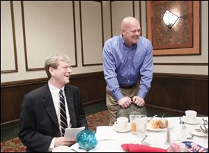 Jon Stainbrook, chairman of the Lucas County Republican party, seated, and Samuel 'Joe the Plumber' Wurzelbacher, who is running for Congress, chat with members of the Greater Toledo Republican Club at its annual banquet.