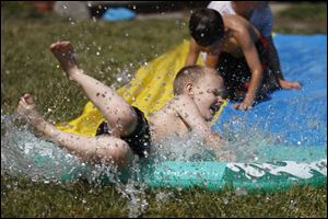 Zachary Gross, 8, cools off on a Slip 'n Slide in the yard of a friend's house on Glendale Avenue. Several meteorologists credit the La Nina weather pattern for the lower 48 states' warmest spring on record. 