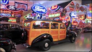 A 1940 Standard Station Wagon is ready for sale, surrounded by period signs. Michael Dingman, 80, relishes neon. 'When I was growing up, you saw neon signs everywhere,' Mr. Dingman recalls. 