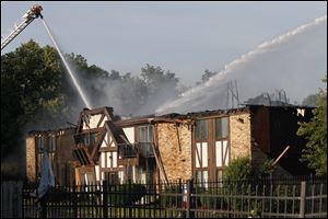 Ladder trucks from the Maumee Fire Department spray the shell of a building in the Quail Ridge Apartments in Maumee. No injuries were reported in the blaze.