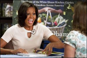 First Lady Michelle Obama signs copies of her book, ‘American Grown: The Story of the White House Kitchen Garden and Gardens Across America, Tuesday in Washington.
