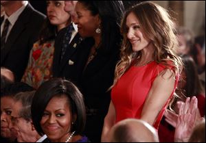 President Barack Obama, not pictured, acknowledges actress Sarah Jessica Parker, as first lady Michelle Obama smiles in the East Room of the White House in Washington, before he presented the 2009 National Medal of Arts and National Humanities Medal.