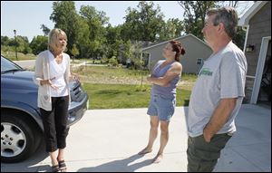 Karen Hensley, left, talks with Ruth and John Insco outside their home in the GrayStone Woods subdivision in Toledo. Ms. Hensley’s husband, Ron Hensley, is co-owner of the subdivision developer.