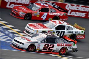 Brad Keselowski (22), Johanna Long (70), and Danny Efland (4) compete in the Nationwide race at Michigan International Speedway.