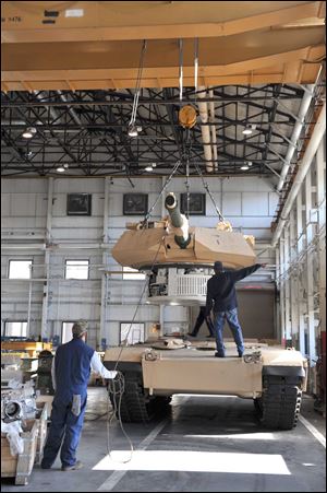 Workers put a turret on an Abrams tank at the General Dynamics Land Systems Joint Systems Manufacturing Center in Lima. The Army intends to use upgraded variants of the tank until at least 2050, but its orders have been filled and the current tank fleet is up to date according to current specifications.
