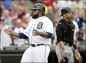Detroit's Prince Fielder, left, scores past Colorado catcher Wil Nieves, right, on a two-RBI single by Detroit's Ramon Santiago in the third inning of Sunday's game in Detroit. The Tigers defeated the Rockies 5-0. 