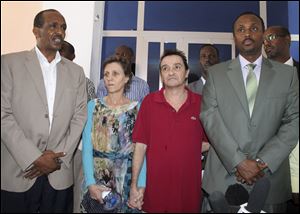 Deborah Calitz, center-left, and Bruno Pelizzari, center-right, give a news conference accompanied by Somali Foreign Minister Abdulahi Haji Hassan, left, and Somali Defense Minister Hussein Arab Isse, right, at the presidential palace a few hours after Calitz and Pelizzari were released by their captors in Mogadishu, Somalia.