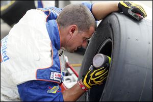 A crew member for the Federated Auto Parts team works on a tire during the Sprint Cup Series Quicken Loans 400 race at the Michigan International Speedway on June 18.
