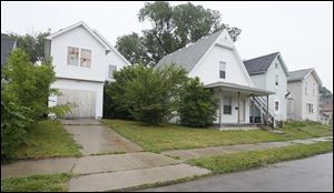 A recently built house on Avondale Avenue is vacant and boarded up, in contrast to nearby older structures, which are occupied.