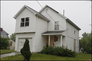 This house at 827 Vance St. is one of the recently built dwellings that now sits vacant and boarded up, with the front-yard shrubbery overgrown.