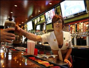 Carley Brusca serves a beer at the Tilted Kilt, in Tempe, Ariz. The Tilted Kilt is part of a booming niche in the beleaguered restaurant industry known as breastaurants, or sports bars that feature scantily-clad waitresses.