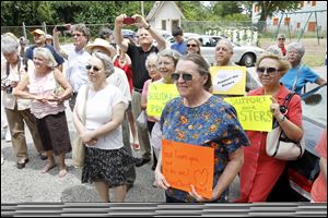 Bev Bingle, right foreground, holds a sign with others who turned out to greet the nuns on the bus tour.