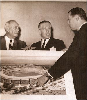Detroit Mayor Jerome Cavanagh, right, shows a drawing of the proposed Olympic Stadium in 1963 to George Romney, center, governor of Michigan, and Kenneth L. 