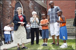 Sisters Simone Campbell, left, and Reg McKillip talk with Terry Crosby, educational director of the Padua Center, and 10-year-old twins Matthew, left, and Mark Henderson.