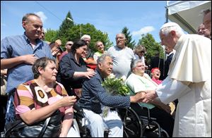 Pope Benedict XVI, right, greets faithful during his visit in the earthquake struck town of Rovereto di Novi, northern Italy, Tuesday.