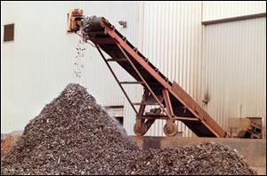 Scrap steel coming off conveyor shredded as finished product at OmniSource Corporation.