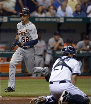 Detroit Tigers' Quintin Berry, left, scores on a single by Delmon Young as Tampa Bay Rays catcher Jose Lobaton, right, fields the wide throw during the third inning Thursday.