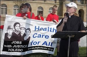 The Rev. Larry C. Clark addresses Thursday's celebratory rally outside the federal courthouse in Toledo, which drew representatives from Jobs With Justice Toledo, health-care experts, and other supporters of the law.