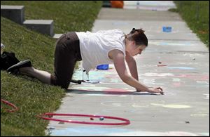 Mandy Lehman of Toledo competes in a sidewalk chalk drawing competition during the Cherry Street Mission Ministries 65th anniversary event Saturday, in Toledo, Ohio.