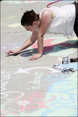 Mandy Lehman of Toledo competes in a sidewalk chalk drawing contest on 18th Street to mark the Cherry Street Mission Ministries’ 65th anniversary downtown. The three-day event, which included Saturday’s contest, wraps up at 3 p.m. today with a church service and celebration at Fifth Third Field.