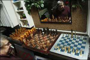 Eric Jensen, 67, begins to reposition chess pieces on his self-designed chess boards at his home in Toledo.