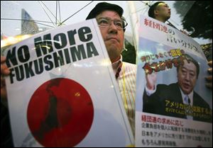 A participant holds a slogan and a photo of Japanese Prime Minister Yoshihiko Noda during a rally protesting the restart of Ohi nuclear power plant, in Tokyo, Sunday.
