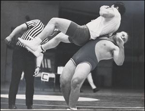 Greg Wojciechowski hoists Rogers High School’s Byron Rhodes as referee Harvey Bowles officiates at the University of Toledo during Olympic trials qualifying rounds in 1968. Wojciechowski finished as runner-up for the Olympic team in 1968, 1972, and 1976. He finally made the team in 1980.