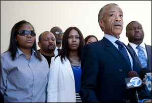 The Rev. Al Sharpton, right foreground, speaks to reporters before the public memorial service for Rodney King in the Hollywood Hills. Behind him Saturday are King's daughters Tristian King, left, and Laura Dene King. 