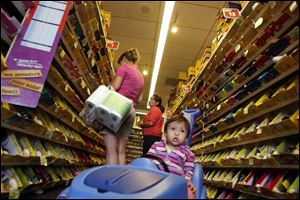 Sylvia Rivas, left, shops for shoes with her 1-year-old daughter Gabriella at a Payless store in Los Angeles. Virtually all the shoes sold at Payless are made overseas and subject to an import tax of as much as 67.5 percent. Shoe tariffs vary widely based on the type of shoe.