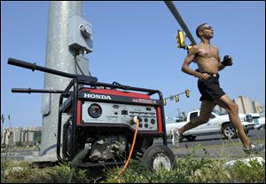 A portable generator supplies power to a traffic signal on Route 1 in Fairfax, Va., Sunday. A severe storm late Friday, June 29th knocked out power to approximately one million residents, traffic signals and businesses in the Washington, DC region. 