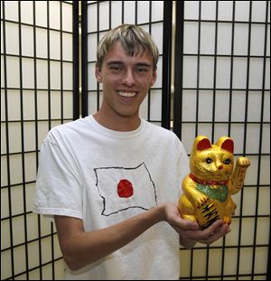 Wayne Brakel, one of the group scheduled to leave July 18, owns Japanese artifacts, including this figurine that is a symbol of welcome.