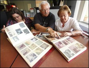Left to right Juanita Barnes, Lonnie Henricks, and Trudy Barnes of the William and Amanda Osterhout Family look at photo albums from past family reunions Friday, 06/29/12, in Swanton, Ohio. The Fulton County family is marking its 60th reunion in July.