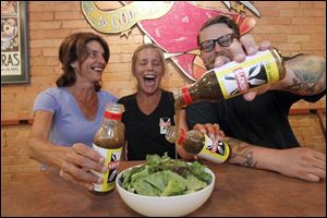 Jennifer Shemak, center, who created the award-winning poppy-seed dressing, is flanked by Sara Bauman, left, and Dustin Hostetler, right at Grumpy's.