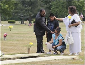 Deacon Willie Sawyer, left, and deaconess Eloise Elliott, right, both of Abundant Life Ministries, comfort Mary Angel of Detroit, Alex Michael Cervantes’ paternal grandmother. She was accompanied Tuesday by her son Luis Valera, 11, at the grave site.
