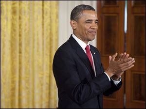President Barack Obama applauds in the East Room of the White House for a group of U.S. service members during a naturalization ceremony.