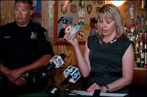 Lynn Sutfin, spokesman for the Michigan Office of Highway Safety Planning, explains the talking urinal cakes during a news conference.